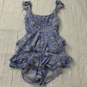 Blue flowery ruffle romper with cutout back detailing.